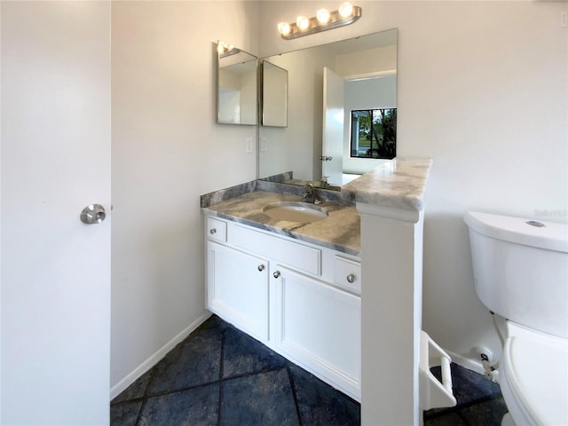 half bathroom featuring toilet, vanity, and baseboards