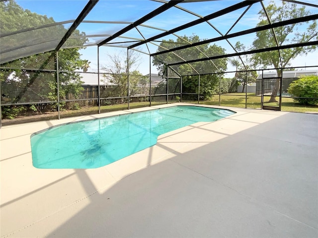 outdoor pool with glass enclosure and a patio