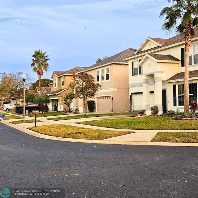 view of property with a residential view, stucco siding, an attached garage, and driveway