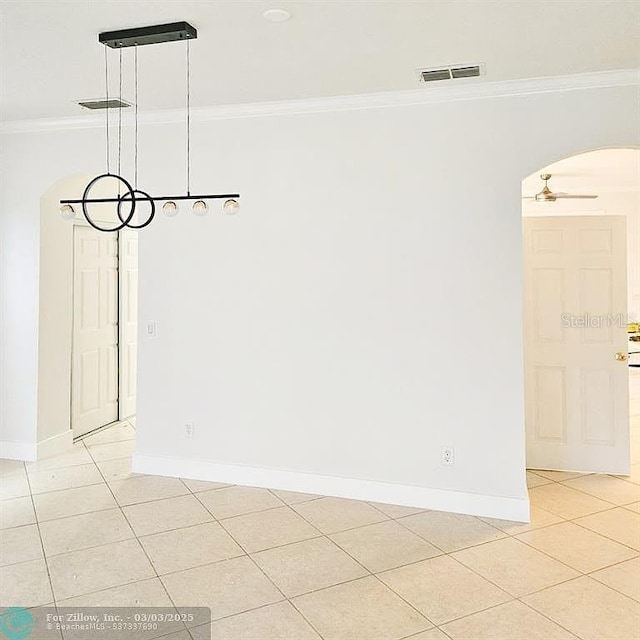 empty room featuring visible vents, arched walkways, crown molding, light tile patterned floors, and baseboards