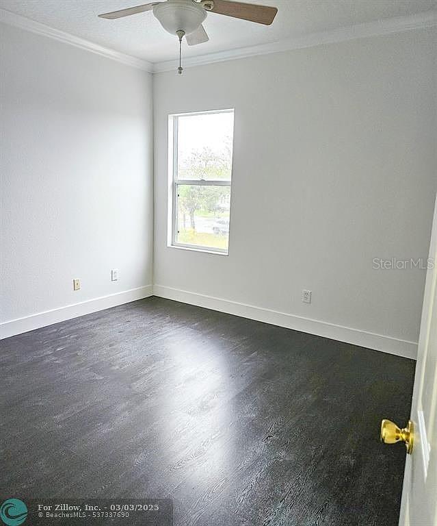 spare room featuring ornamental molding, baseboards, and ceiling fan