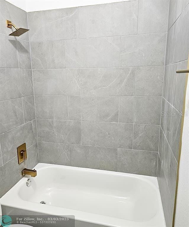 bathroom with bathing tub / shower combination