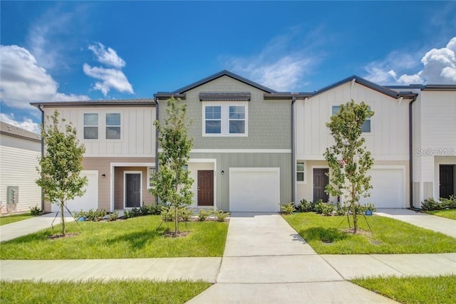 multi unit property featuring an attached garage, board and batten siding, concrete driveway, and a front lawn