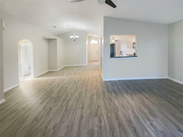 unfurnished living room with vaulted ceiling, wood finished floors, and ceiling fan with notable chandelier