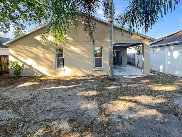 back of house featuring a patio area, stucco siding, and fence