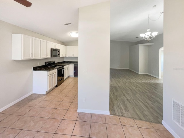 kitchen with light tile patterned floors, visible vents, white cabinetry, and black appliances