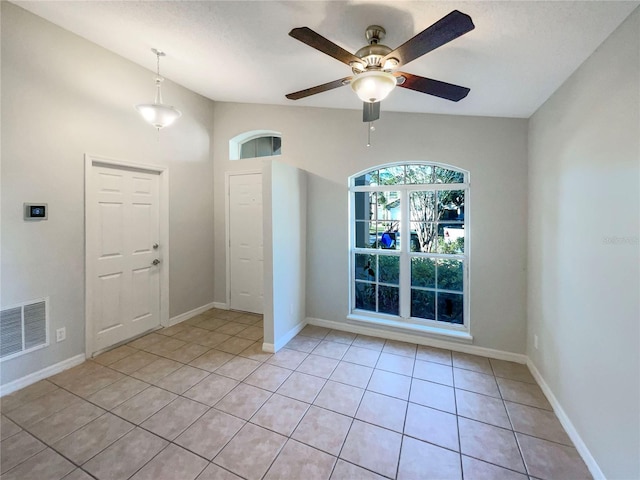 spare room featuring light tile patterned floors, visible vents, baseboards, and ceiling fan