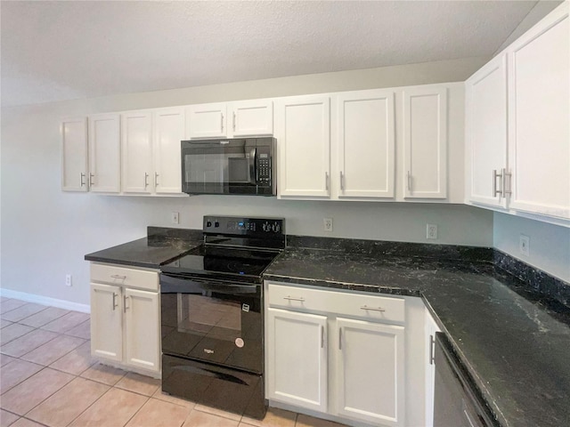 kitchen with white cabinetry, black appliances, light tile patterned floors, and dark stone counters