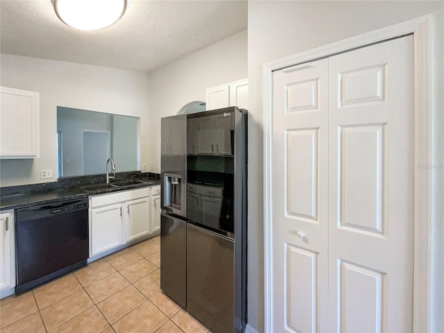 kitchen with light tile patterned floors, a sink, black dishwasher, stainless steel refrigerator with ice dispenser, and white cabinetry