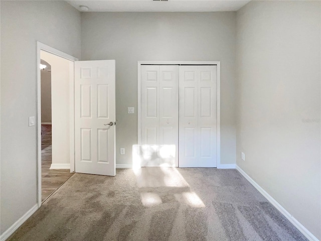 unfurnished bedroom with a closet, baseboards, and carpet floors