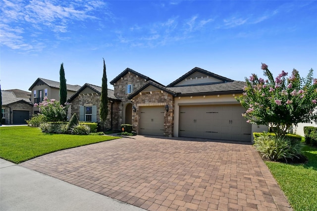 view of front of house with a front lawn, a tile roof, decorative driveway, a garage, and stone siding