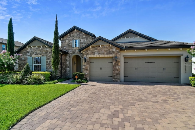 craftsman-style house with an attached garage, stucco siding, a front lawn, a tile roof, and decorative driveway