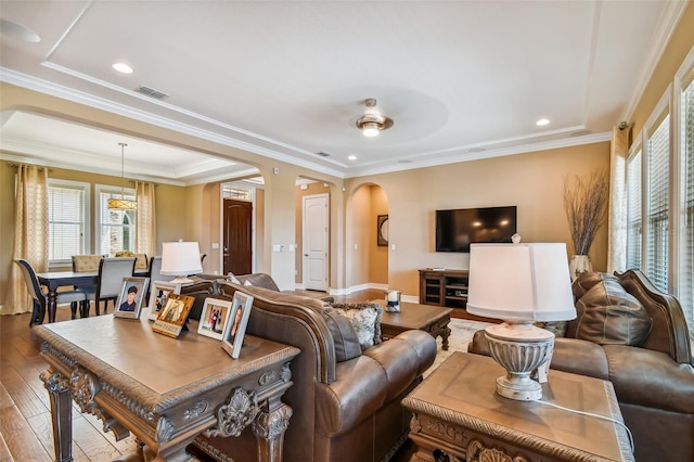 living area featuring visible vents, recessed lighting, arched walkways, ornamental molding, and hardwood / wood-style flooring