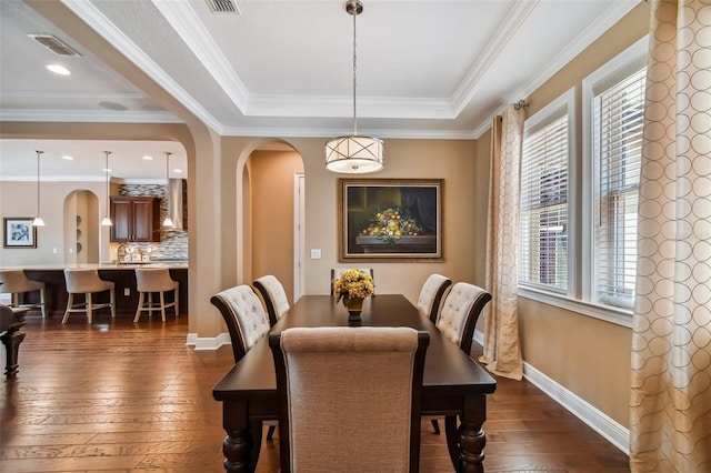 dining space featuring arched walkways, visible vents, dark wood finished floors, and baseboards