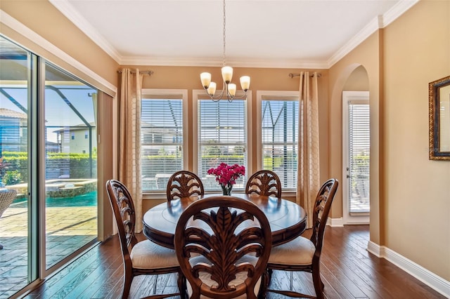 dining area featuring dark wood-style floors, arched walkways, baseboards, and an inviting chandelier