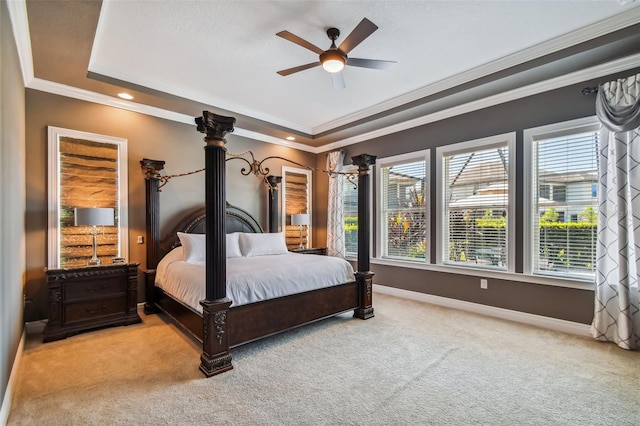 carpeted bedroom with multiple windows, a raised ceiling, and baseboards