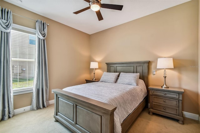 bedroom featuring baseboards, light carpet, and a ceiling fan