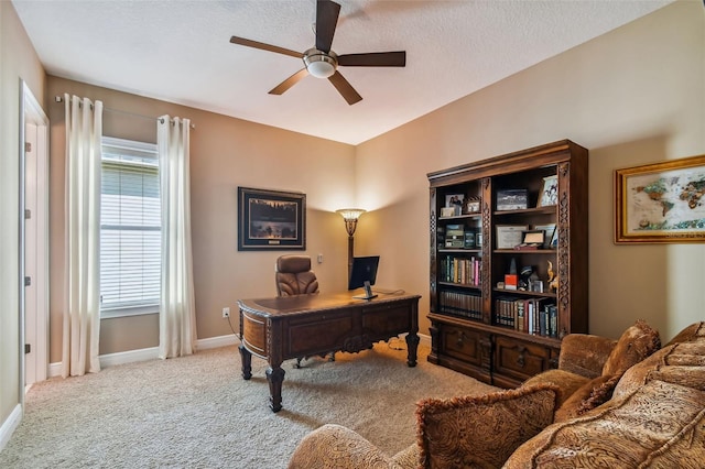 carpeted home office with baseboards, a textured ceiling, and ceiling fan