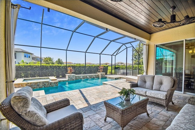 view of swimming pool with a pool with connected hot tub, glass enclosure, a patio, outdoor lounge area, and a ceiling fan