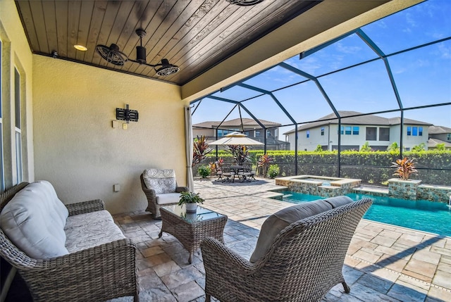 view of patio / terrace with glass enclosure, a residential view, a ceiling fan, and a pool with connected hot tub