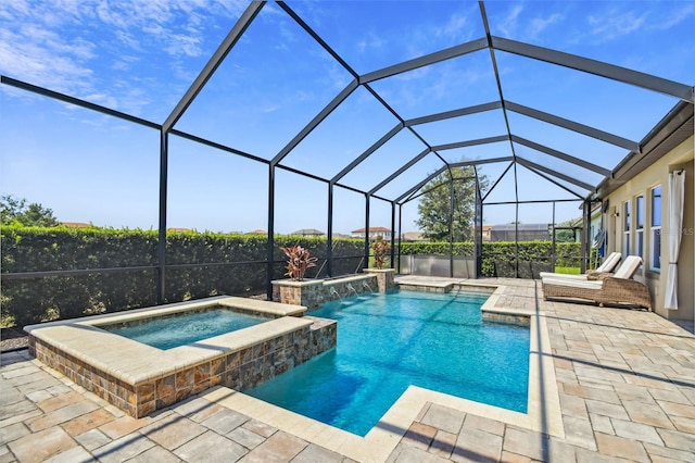 outdoor pool featuring glass enclosure, an in ground hot tub, and a patio area