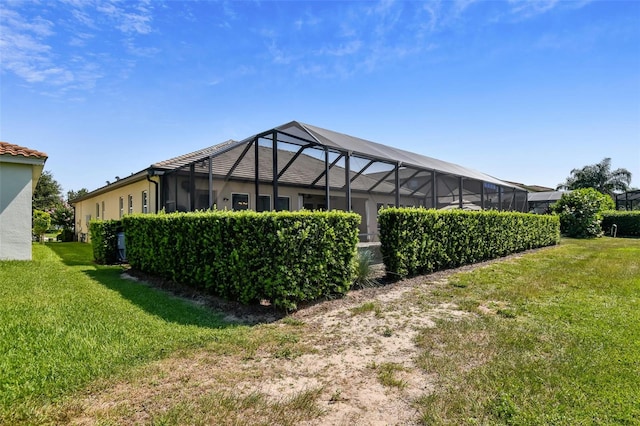 back of property with a lanai, a lawn, and stucco siding