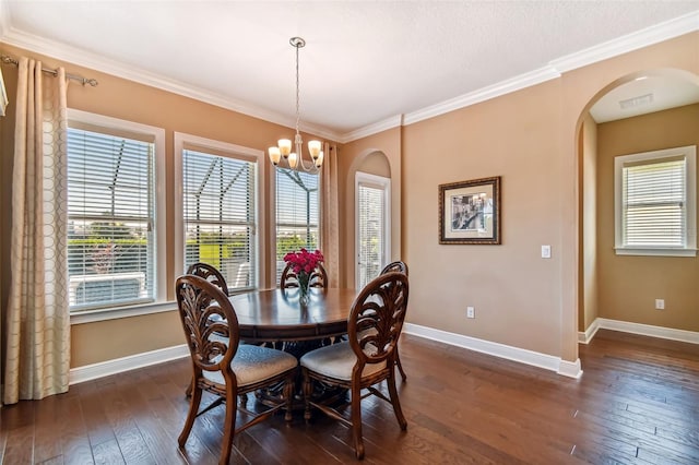 16736 Broadwater Ave, Winter Garden, FL 34787 - dining space featuring arched walkways, a chandelier, dark wood finished floors, and crown molding