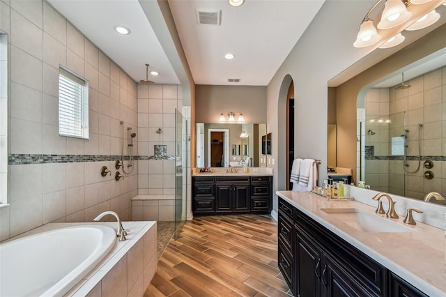 16736 Broadwater Ave, Winter Garden, FL 34787 - full bath with tiled shower, a bath, two vanities, recessed lighting, and wood finished floors