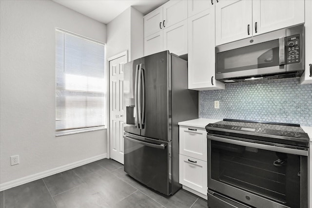 kitchen with tasteful backsplash, appliances with stainless steel finishes, white cabinets, and light countertops