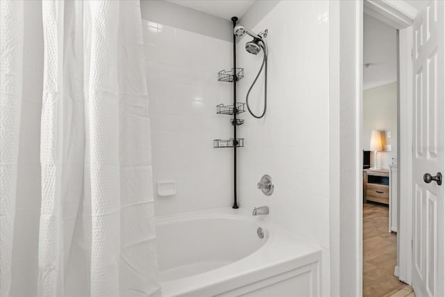 ensuite bathroom featuring ensuite bath, wood finished floors, and shower / bathtub combination with curtain