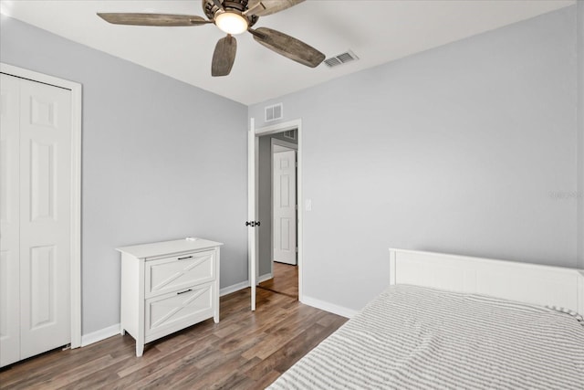 bedroom with wood finished floors, visible vents, and baseboards