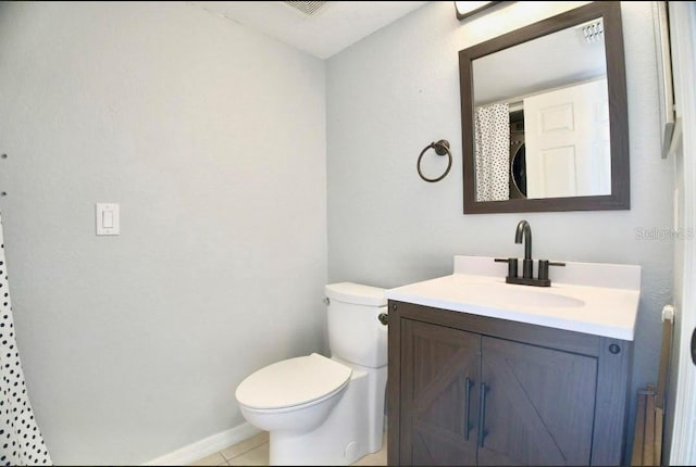 bathroom featuring tile patterned floors, visible vents, toilet, stacked washing maching and dryer, and vanity