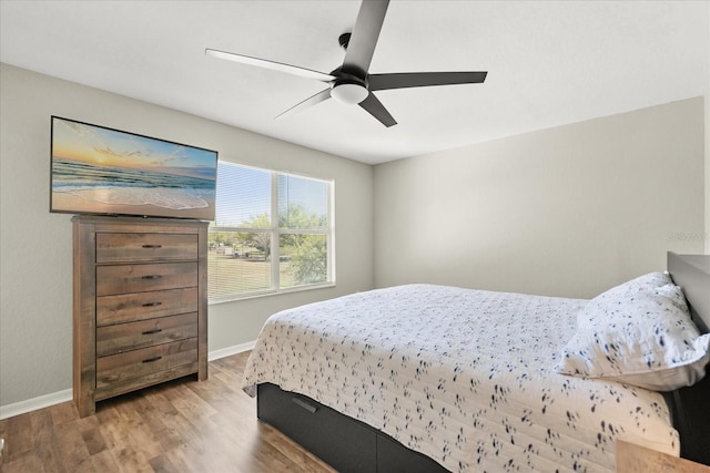 bedroom featuring wood finished floors, a ceiling fan, and baseboards