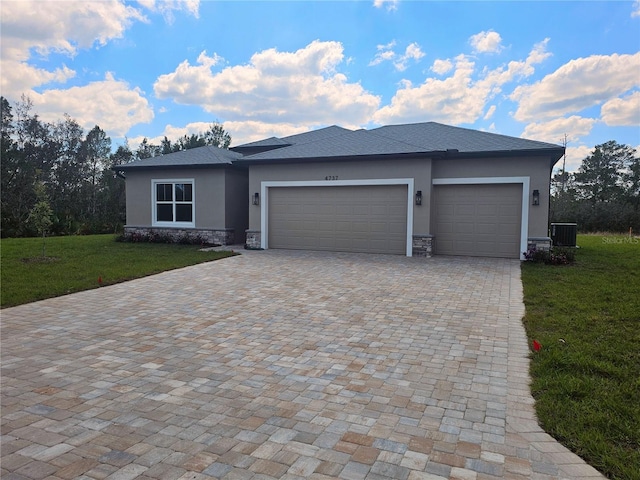 view of front of house with stucco siding, central air condition unit, decorative driveway, stone siding, and an attached garage