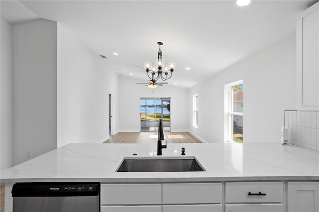 kitchen featuring a sink, stainless steel dishwasher, an inviting chandelier, and white cabinets
