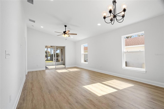 unfurnished room with visible vents, ceiling fan with notable chandelier, light wood-type flooring, and baseboards