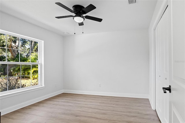 empty room with visible vents, ceiling fan, baseboards, and light wood-style floors