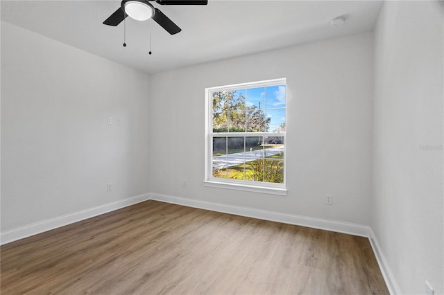 spare room with ceiling fan, baseboards, and wood finished floors