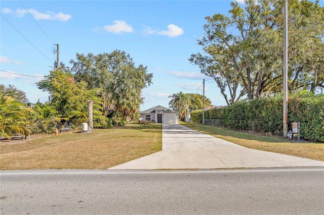 view of front of house with concrete driveway and a front lawn