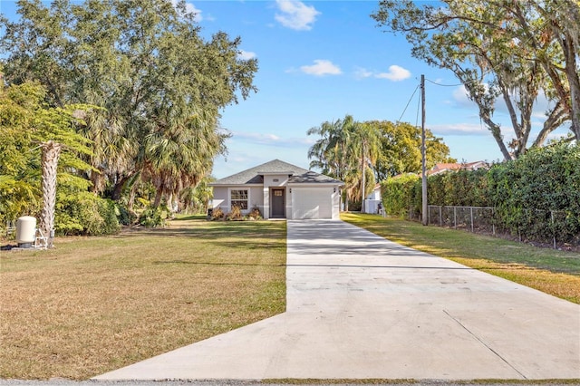 view of front of home featuring a front yard, fence, a garage, and driveway