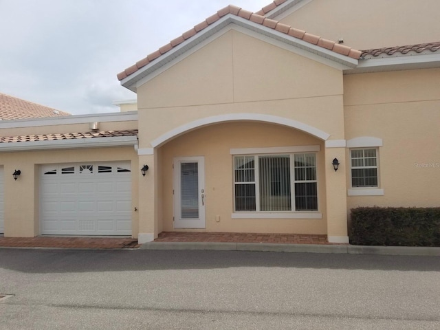 view of front of house featuring a tiled roof and stucco siding