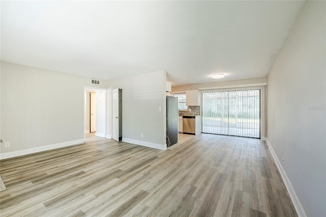 5210 Grandview Dr, Orlando, FL 32808 - unfurnished living room with light wood finished floors, visible vents, and baseboards