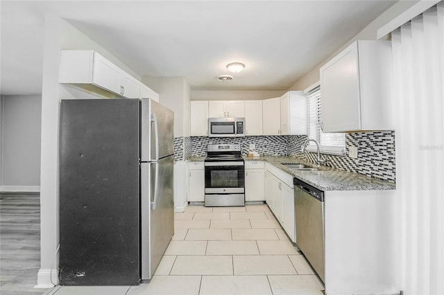 5210 Grandview Dr, Orlando, FL 32808 - kitchen with a sink, white cabinets, and stainless steel appliances