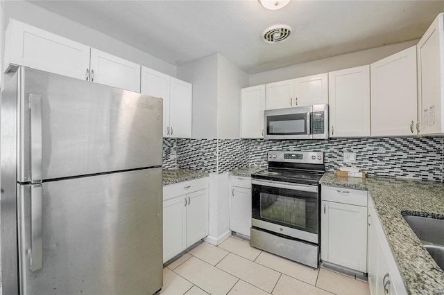 5210 Grandview Dr, Orlando, FL 32808 - kitchen featuring visible vents, white cabinets, stainless steel appliances, and decorative backsplash