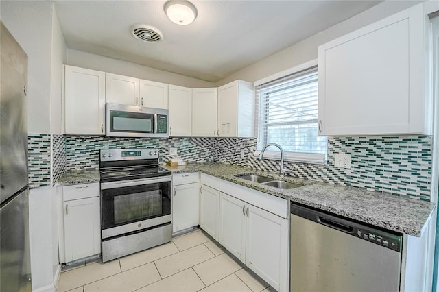 5210 Grandview Dr, Orlando, FL 32808 - kitchen with a sink, white cabinets, visible vents, and stainless steel appliances
