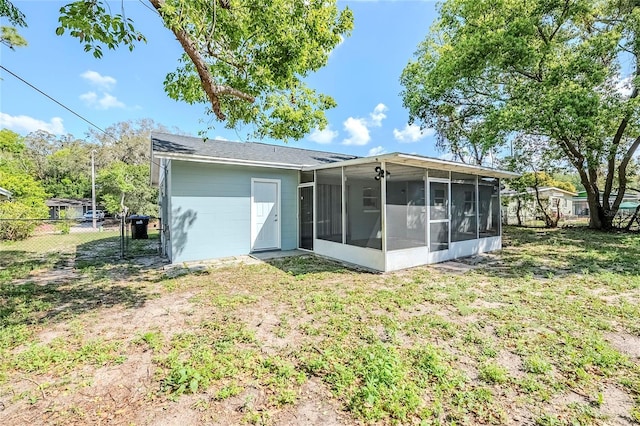 5210 Grandview Dr, Orlando, FL 32808 - back of property with a gate, fence, a lawn, and a sunroom