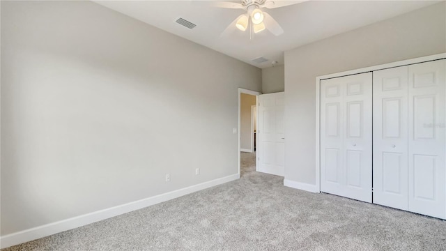 unfurnished bedroom featuring visible vents, a closet, carpet, baseboards, and ceiling fan