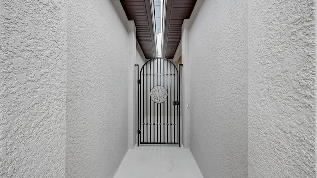 entrance to property featuring a gate and stucco siding