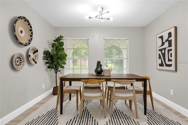 dining area with an inviting chandelier, light wood-type flooring, and baseboards