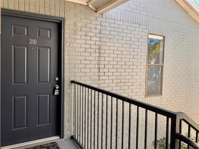 doorway to property featuring brick siding